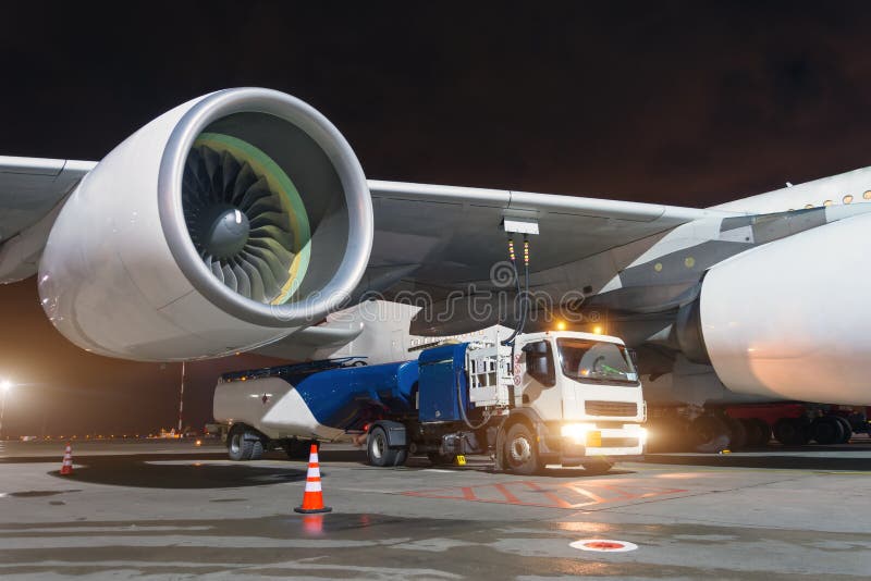 Motori a propulsione del grande aereo, rifornenti un aeroplano di combustibile enorme, un camion con combustibile con i tubi fles