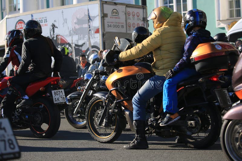 Motorista con un niño en su motocicleta entre otros motoristas fotos de archivo libres de regalías Motorista con un niño en su motocicleta entre otros motoristas fotos de archivo libres de regalías