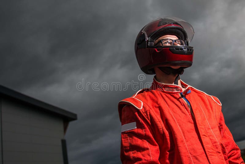 Motorista de carro de corridas que veste o capacete protetor