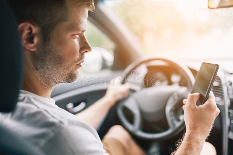 Motorista descuidado que usa um telefone celular enquanto conduzindo fotografia de stock Motorista descuidado que usa um telefone celular enquanto conduzindo fotografia de stock