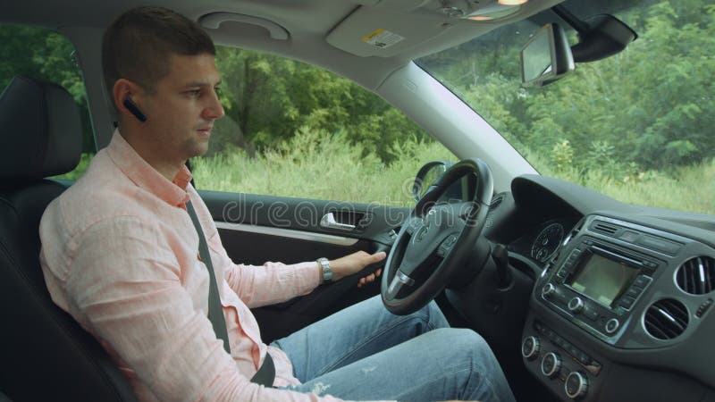 Motorista masculino positivo que usa o computador da viagem no carro