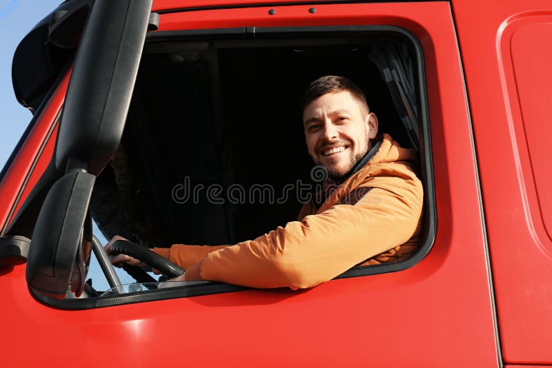 Motorista masculino que olha fora do caminhão fotografia de stock royalty free Motorista masculino que olha fora do caminhão fotografia de stock royalty free