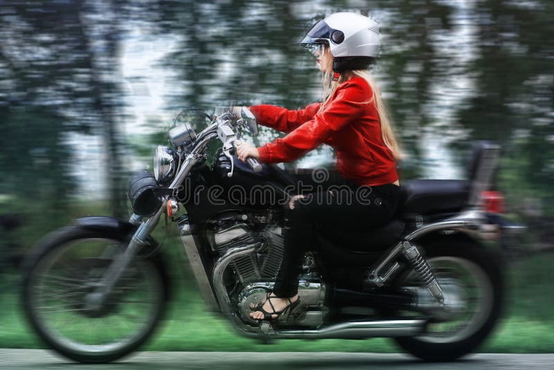 Shot of an attractive woman biker posing near her motorcycle. Shot of an attractive woman biker posing near her motorcycle.