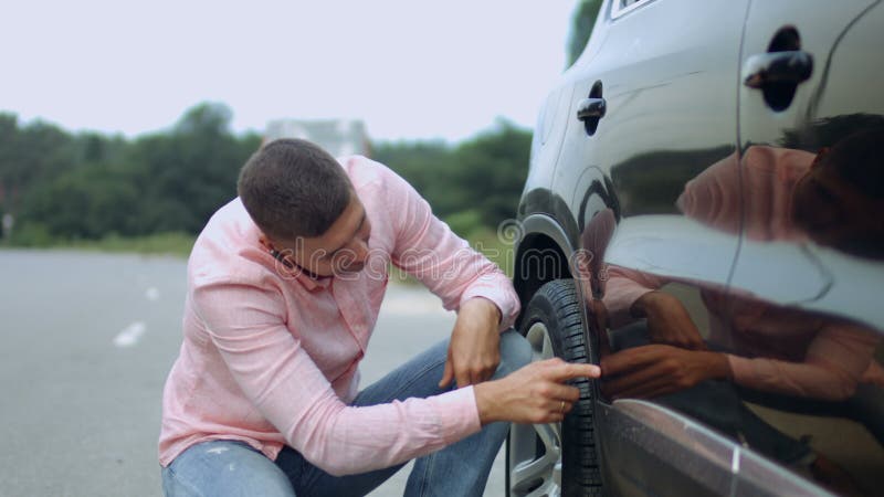 Motorista virado que olha riscos e dentes no carro