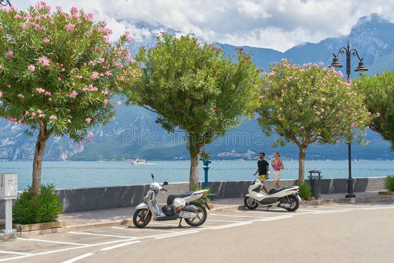 Motorowerzyści i turyści na promenadzie nad brzegiem jeziora garda w popularnym kurorcie limone sul garda obraz royalty free