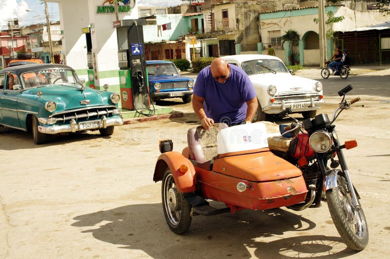 Motorrad mit einem Beiwagen an der Tankstelle in Kuba lizenzfreie stockbilder Motorrad mit einem Beiwagen an der Tankstelle in Kuba lizenzfreie stockbilder