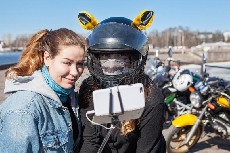 Motorradfahrer der jungen Frauen nehmen selfies mit Mobiltelefon mit dehnbarem monopod stockfotografie Motorradfahrer der jungen Frauen nehmen selfies mit Mobiltelefon mit dehnbarem monopod stockfotografie