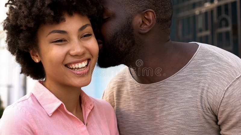 Mots de chuchotement d'ami africain de l'amour à l'amie, couple de sourire heureux image libre de droits Mots de chuchotement d'ami africain de l'amour à l'amie, couple de sourire heureux image libre de droits