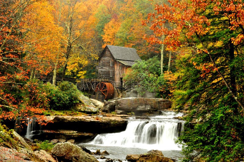 Moulin de blé à moudre entouré par des lames d'automne images stock Moulin de blé à moudre entouré par des lames d'automne images stock