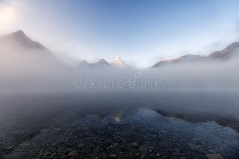 Mount Assiniboine in blue foggy reflection on Lake Magog at Provincial park