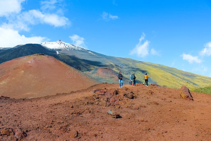 Mount Etna, Sicily, Italy - April 9th 2019: Tourists admiring the volcanic landscape around Etna volcano. Snow on the very top royalty free stock images Mount Etna, Sicily, Italy - April 9th 2019: Tourists admiring the volcanic landscape around Etna volcano. Snow on the very top royalty free stock images