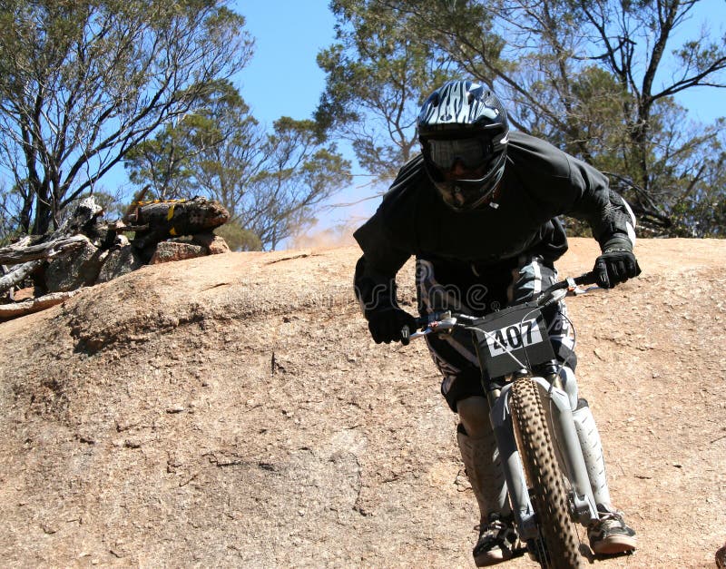 Extreme mountain biker landing jump off rock