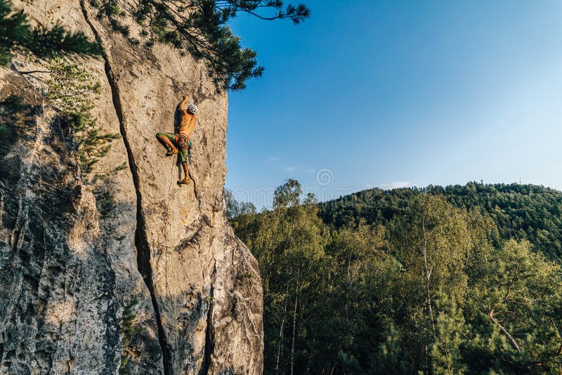 Mountain Climber Climbing the Cliff Using His Climbing Equipment