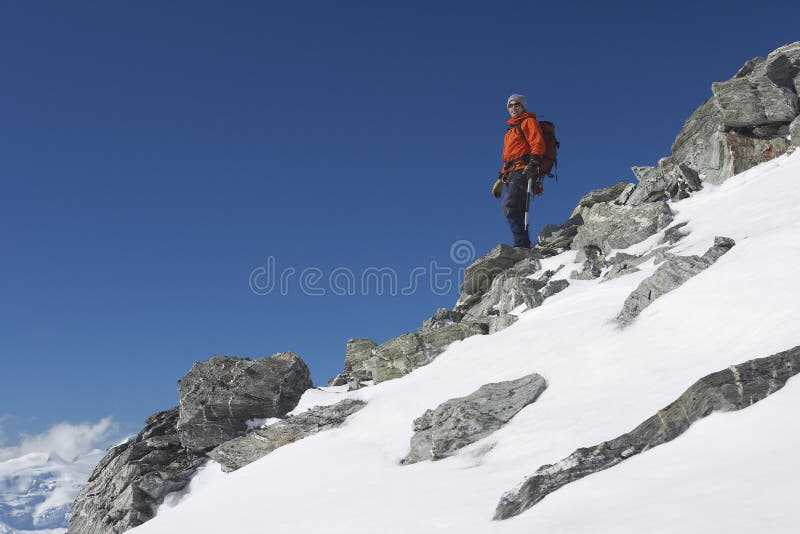 Mountain Climber Descending Snow And Boulder Slope stock photography