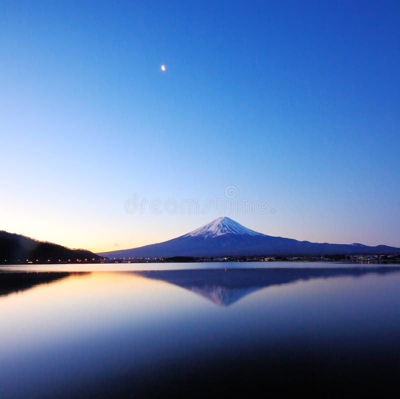 Il monte Fuji e la sua riflessione sul lago kawaguchi a freddo mattino d'inverno, con le luci sul ponte.