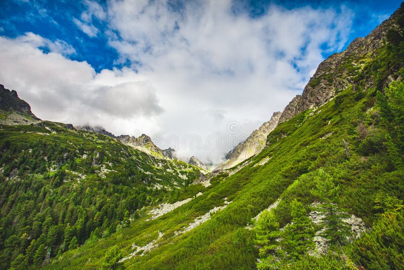 Mountain green hill against blue cloudy sky