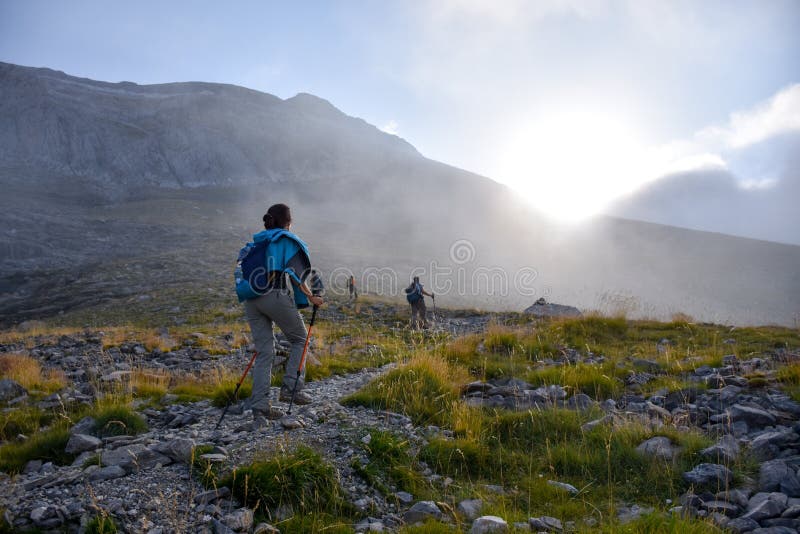 Mountain hikers at sunrise on a rocky path