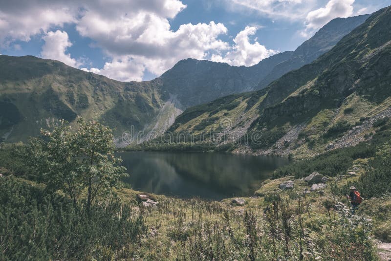 Mountain lake panorama view in late summer in Slovakian Carpathian Tatra with reflections of rocky hills in water. Rohacske plesa