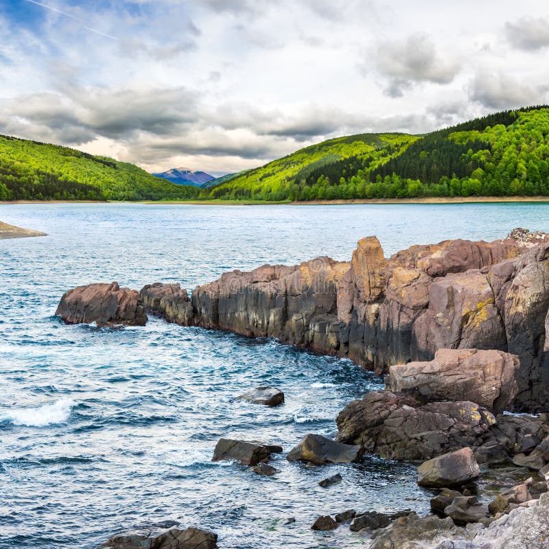 Mountain lake with rocky shore at sunrise