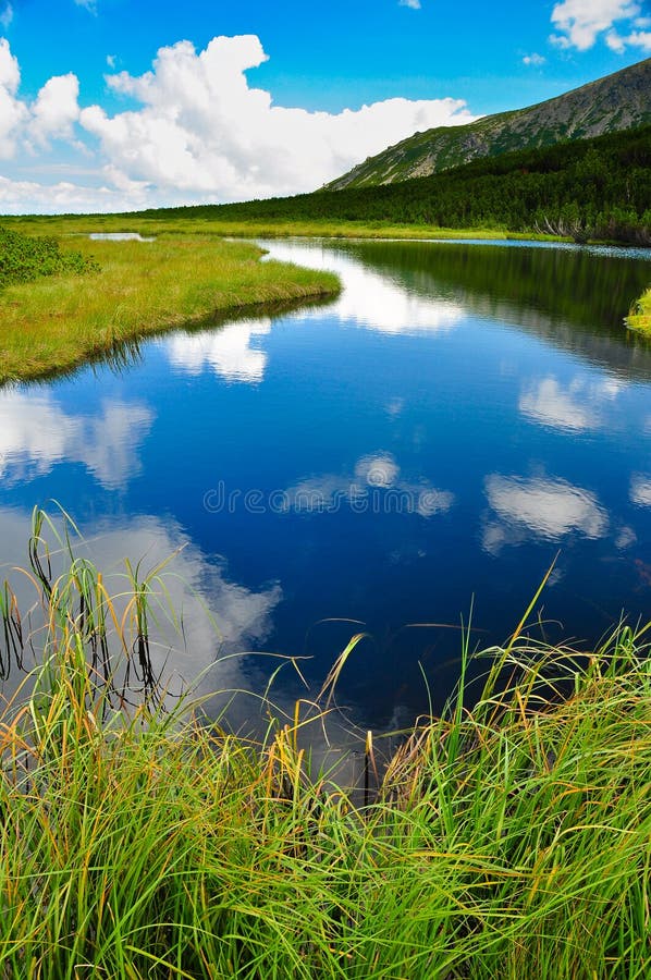 Horské jezero nebe a mraky odraz