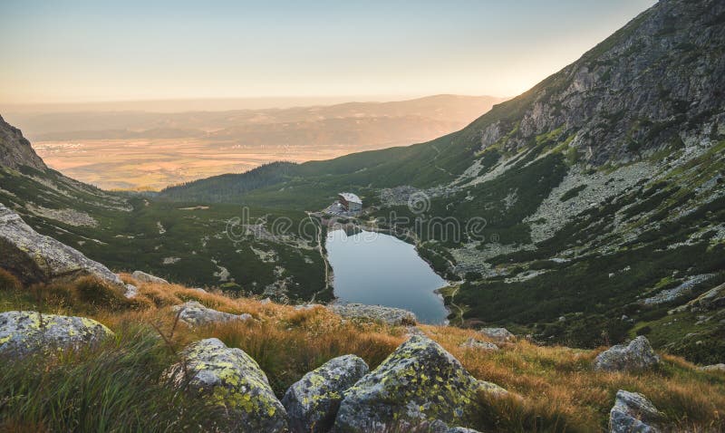 Horské jezero při západu slunce s kameny v popředí