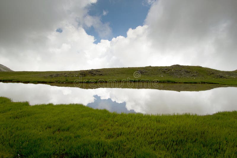 Mountain lake with symetrical reflection of clouds