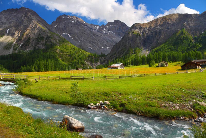 Summer mountain landscape with chalet on a meadow and stream in foreground, Sertig Dorfli, Davos, Switzerland