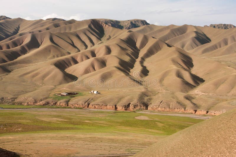 Mountain landscape with original natural patterns and a small destroyed farm