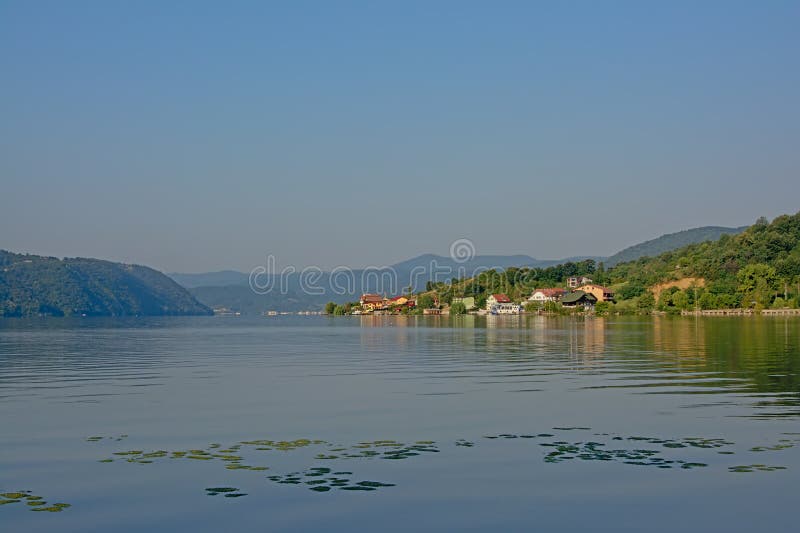 Landscape with mountains and village on the embankments of river Danube, Romania in early morning light royalty free stock image Landscape with mountains and village on the embankments of river Danube, Romania in early morning light royalty free stock image