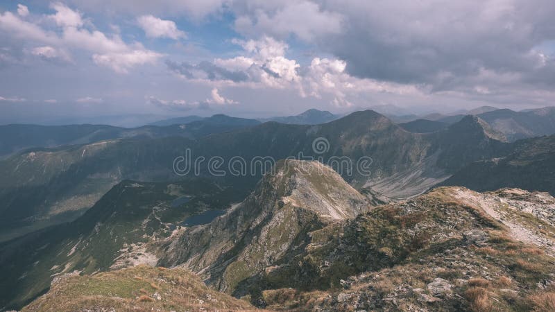 Horské panorama z vrcholu baníkov ve slovenských tatrách se skalnatou krajinou a stíny turistů za jasného dne