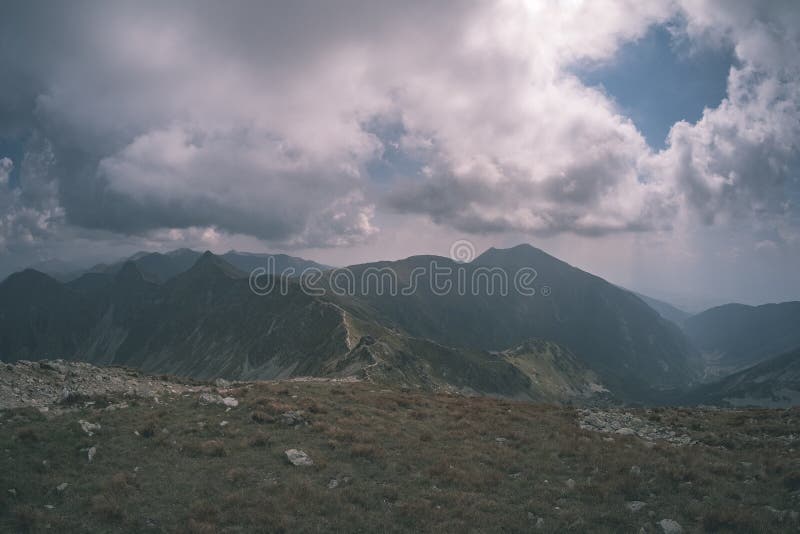 Horská panoráma z vrcholu baníkov v slovenských tatrách so skalnatou krajinou a tieňmi turistov za jasného dňa