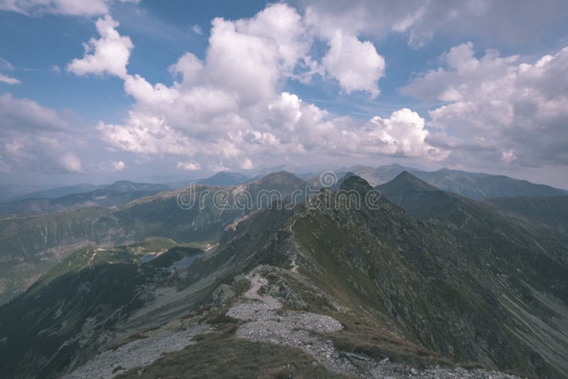 Horská panoráma z vrcholu baníkov v slovenských tatrách so skalnatou krajinou a tieňmi turistov za jasného dňa