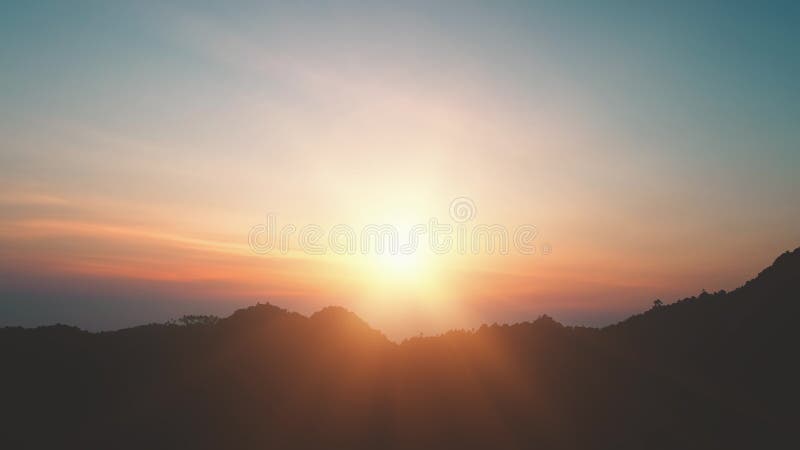 Mountain peak silhouette colorful sunrise. Bright sun rise up over mount range with blue orange cloud