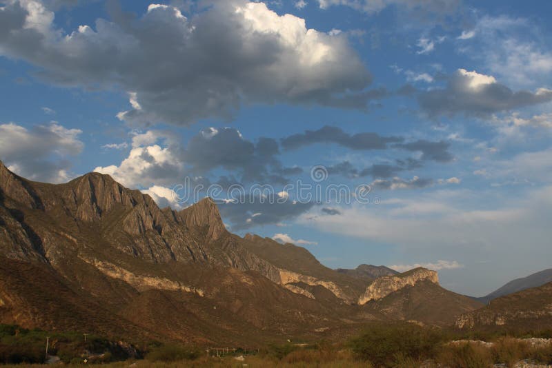 Mountain range with a semi cloudy sky. This image shows the mountain range of northern Mexico, with a beautiful cloudy landscape on the background royalty free stock photography Mountain range with a semi cloudy sky. This image shows the mountain range of northern Mexico, with a beautiful cloudy landscape on the background royalty free stock photography