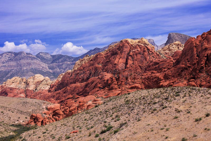 Mountain ranges in Red Rock, Nevada. The rocks are vivid red, orange and dark brown, and show signs of heavy erosion. The sky is b royalty free stock images Mountain ranges in Red Rock, Nevada. The rocks are vivid red, orange and dark brown, and show signs of heavy erosion. The sky is b royalty free stock images