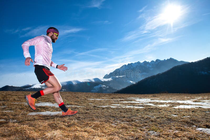 Mountain runner in downhill action on slippery ground stock photography Mountain runner in downhill action on slippery ground stock photography