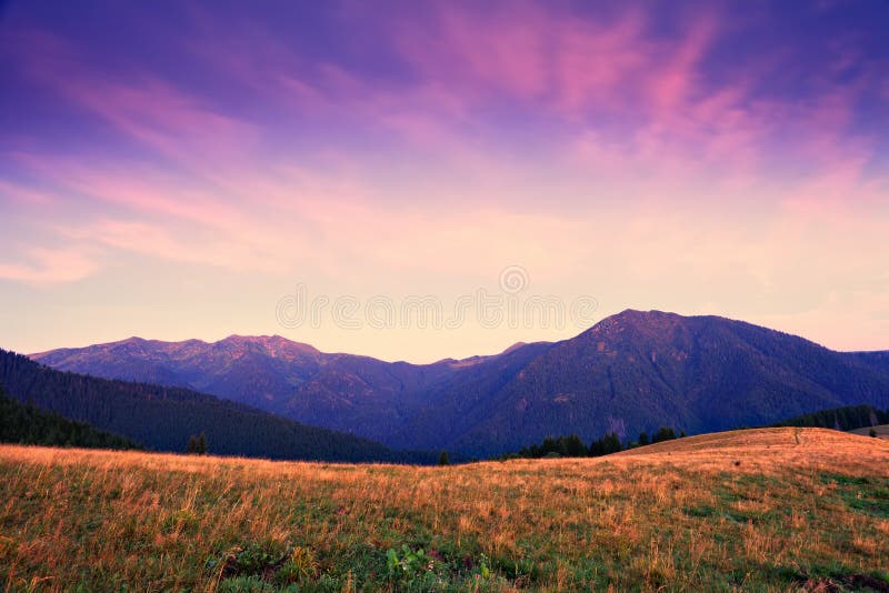 Mountain sunrise with pink and violet clouds