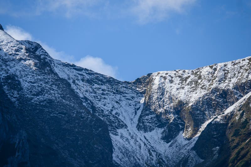 Mountain tops in autumn covered in mist or clouds in sunny day