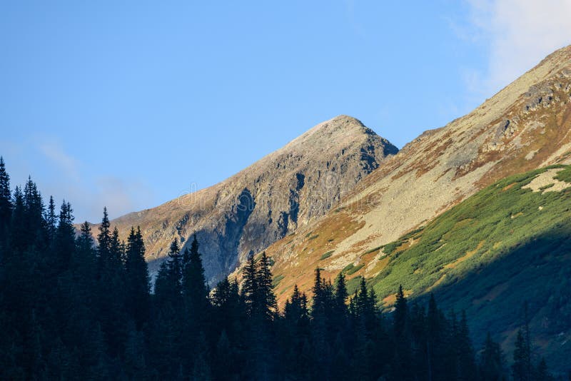 Mountain tops in autumn covered in mist or clouds in sunrise li