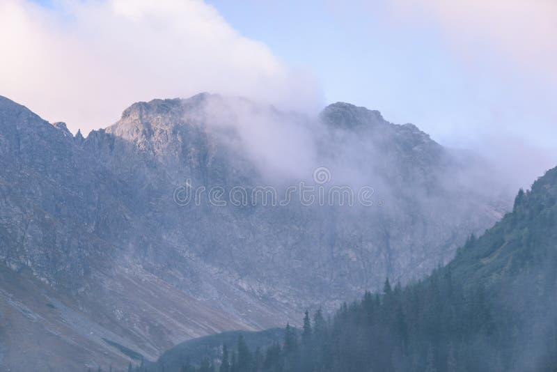 Mountain tops in autumn covered in mist or clouds - vintage ret