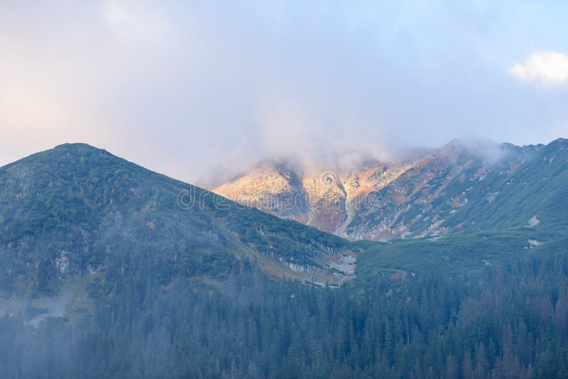 Mountain tops in autumn covered in mist or clouds