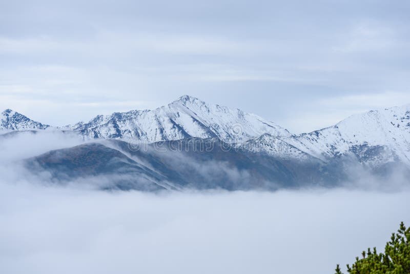 Mountain tops in autumn covered in mist or clouds