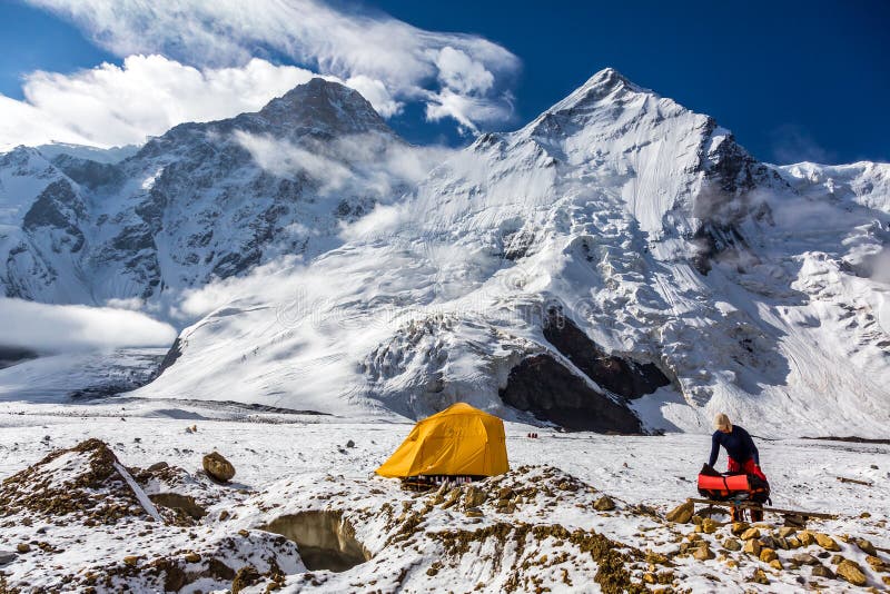 Mountain View Orange Tent Alpinist Holding Backpack stock photo Mountain View Orange Tent Alpinist Holding Backpack stock photo