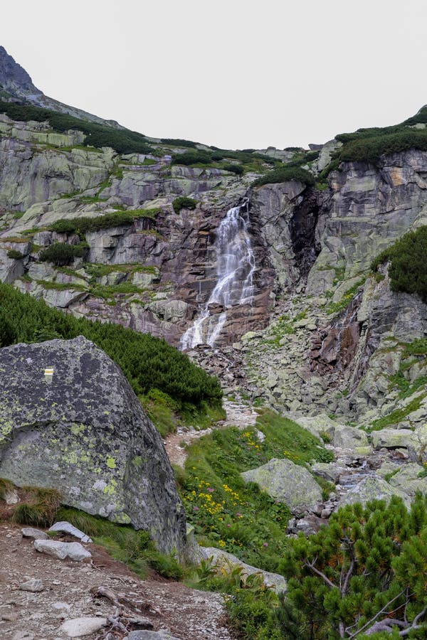 Horský vodopád vo Vysokých Tatrách Skok. Vysoké skaly pokryté krovinami