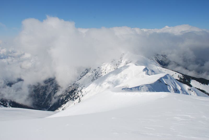 Mountain winter slope in clouds.