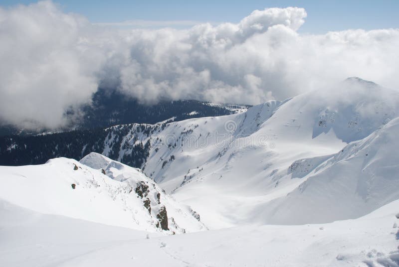 Mountain winter slope in clouds.