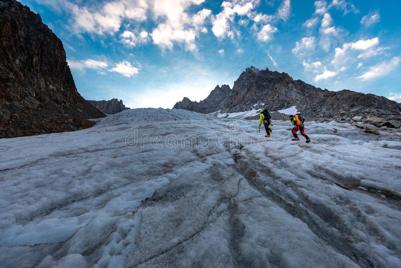 Two mountaineers alpinists sportsmen ice climbing Aiguille du Tour walking glacier beautiful landscape view, Mont Blanc mountains massif range, french alps alpinism travel, Europe nature tourism destination. Two mountaineers alpinists sportsmen ice climbing Aiguille du Tour walking glacier beautiful landscape view, Mont Blanc mountains massif range, french alps alpinism travel, Europe nature tourism destination