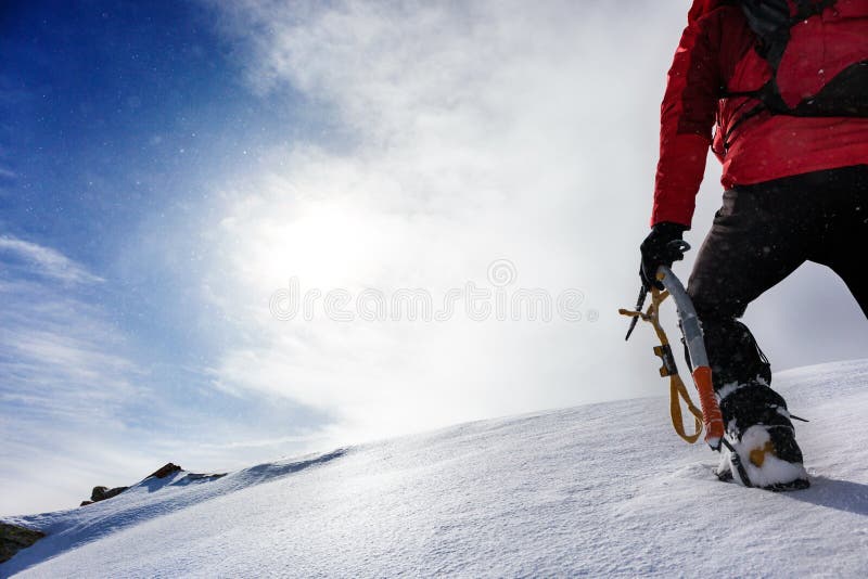 Mountaineer climbing a snowy peak in winter season.