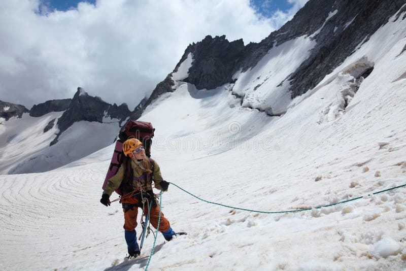 Mountaineer girl belaying friends by rope