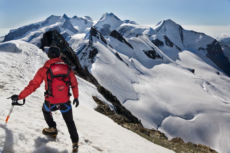 Mountaineer walks down along a snowy ridge stock image
